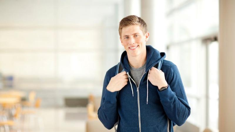 male student standing with backpack